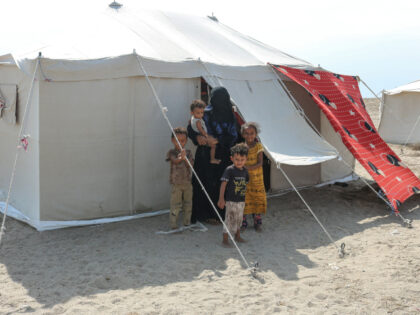 Internally displaced people (IDPs) are seen outside their tent at Al-Farsi displacement ca