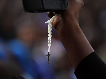 A Christian faithful holding a rosary attends a march on the streets of Abuja during a pra