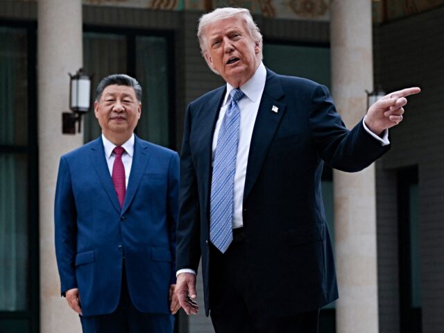 US President Donald Trump (R) gestures as he poses for photos with China’s President Xi