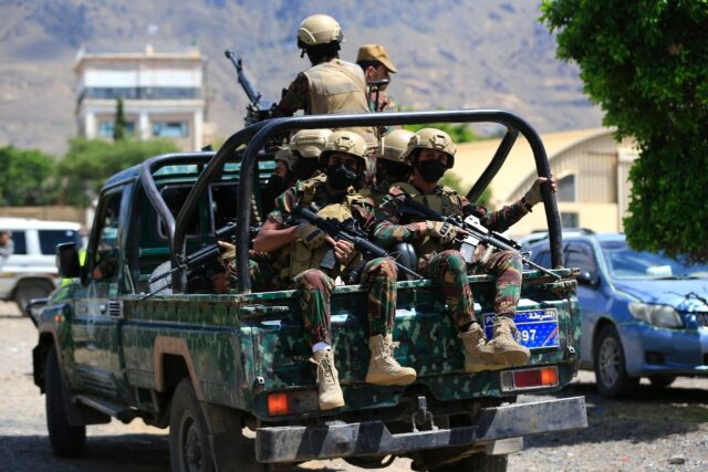 Yemen's Houthi armed forces patrol as Yemeni prisoners loyal to the Houthi authoritie