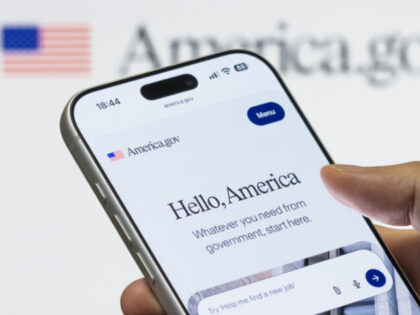 n this photo illustration, a smartphone displaying the America.gov homepage is held in fro