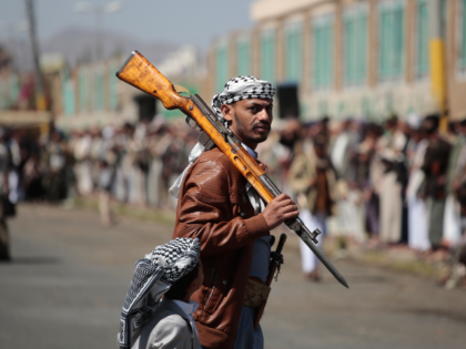 A Houthi supporter carries a rifle while attending an armed tribal rally in Sanaa, Yemen,