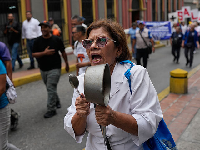  A woman bangs a pot during a pr