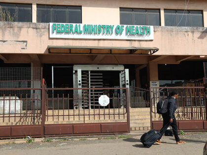 Title: Africa Ebola Image ID: 26294382070249 Article: A woman walks past the Federal Minis