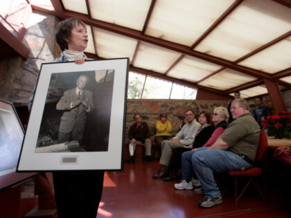 Tour guide Kathy Deering, left, holds up a portrait of Wright during a tour.Taliesin West