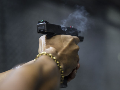 A member shoot a gun at the firing range inside the Colt 45 Shooting Club in Rio de Janeir