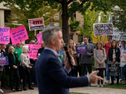 Commissioner Bob Harvie speaks as abortion rights activists protest during a "Bans Off Our