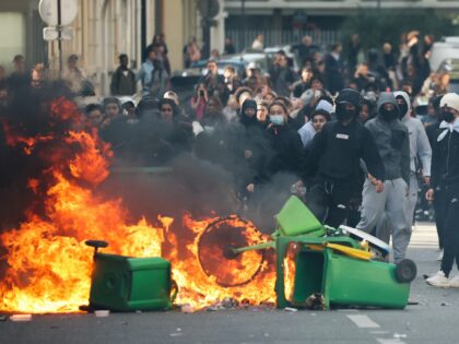 TOPSHOT - A student puts trashes into a fire as protesting students carry out blockading a