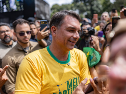 Flavio Bolsonaro, Brazilian presidential candidate, center, greets supporters during a clo