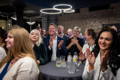 Supporters of Latvia's Prime Minister Andris Kulbergs applaud as he speaks after the first