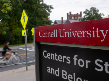 ITHACA, NEW YORK - SEPTEMBER 30: Students walk and ride across the campus of Cornell Unive