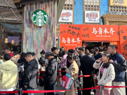 People queue to enter a newly-opened Starbucks at the Grand Bazaar in Urumqi, in China's n