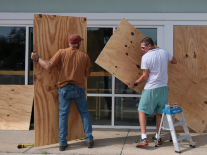 GULF BREEZE, FLORIDA- OCTOBER 08: (L-R) David Schisler and Courtney Head place plywood ove