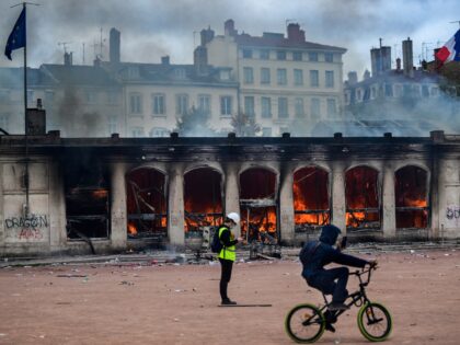 People are in front of Lyon's tourism office set on fire during a demonstration to protest