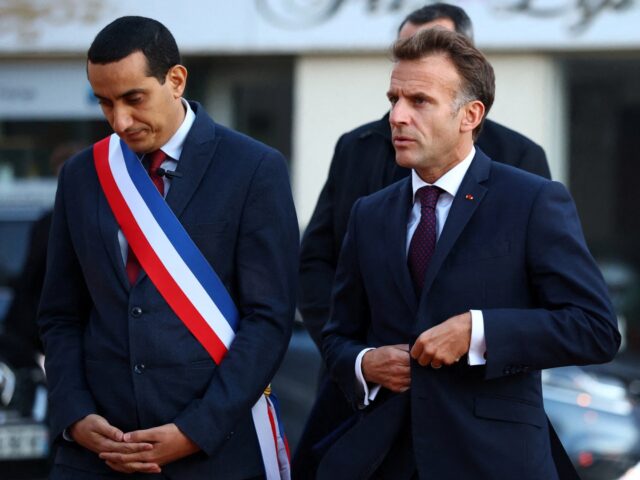 France's President Emmanuel Macron (R) walks with Mayor of Trappes Ali Rabeh as he arrives