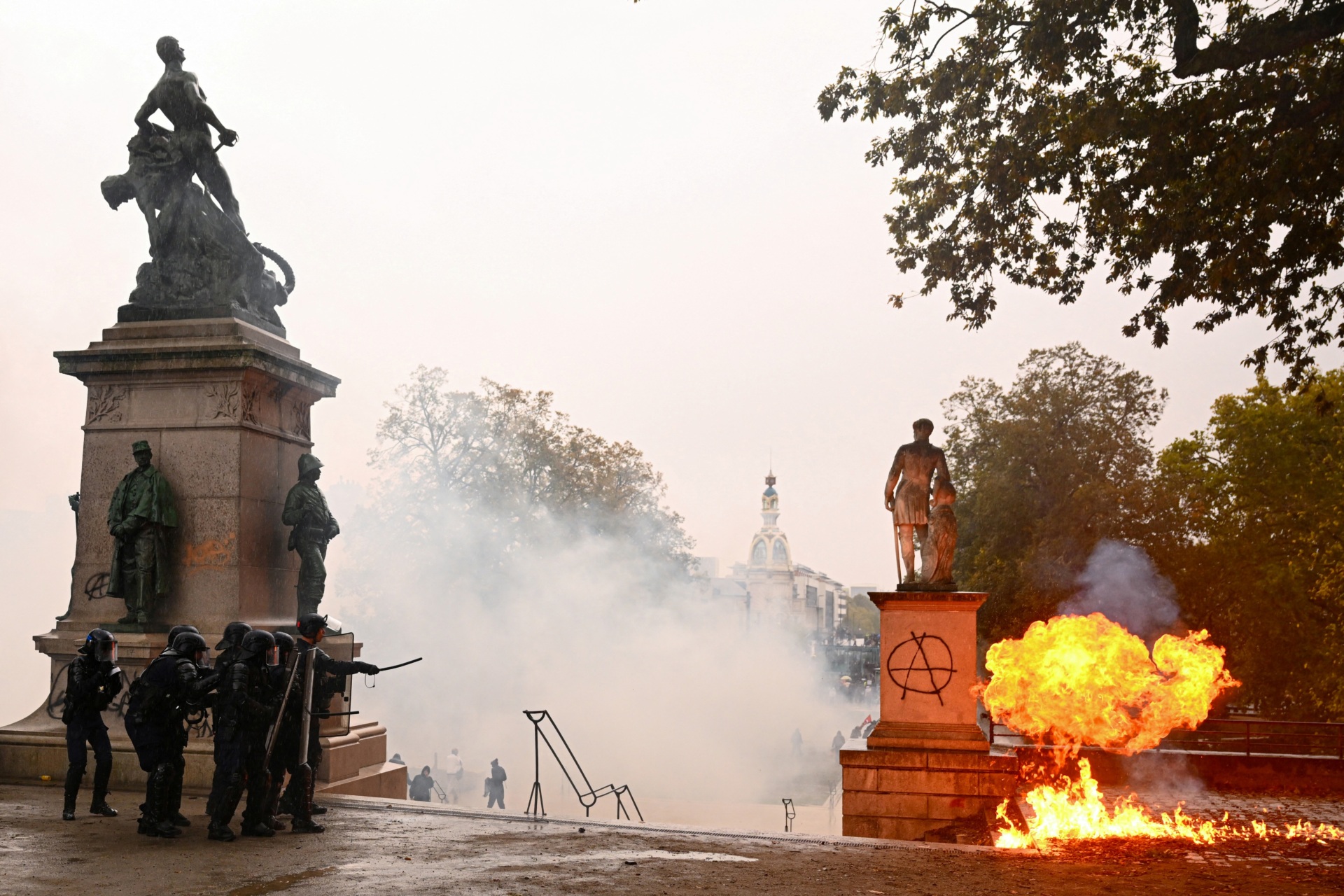 French Police officers in riot gear operate as a Molotov cocktail explodes on the Cours Saint-Andre during a demonstration in favor of purchasing power, the protection of public services, and fiscal and social justice, in Nantes, western France on October 24, 2026 as part of a nationwide call for mobilisation bringing together former members of the Yellow Vest movement, labor unions, high school and university students. Protests by high school students over learning conditions sparked a movement that has since spread nationwide, fuelled by broader anger over the rising cost of living. About 70,000 security personnel will be deployed on October 24, 2026, Interior Minister said at a news conference, warning that calls for violence and looting were circulating on social media. (Photo by Guillaume Saligot / AFP via Getty Images)