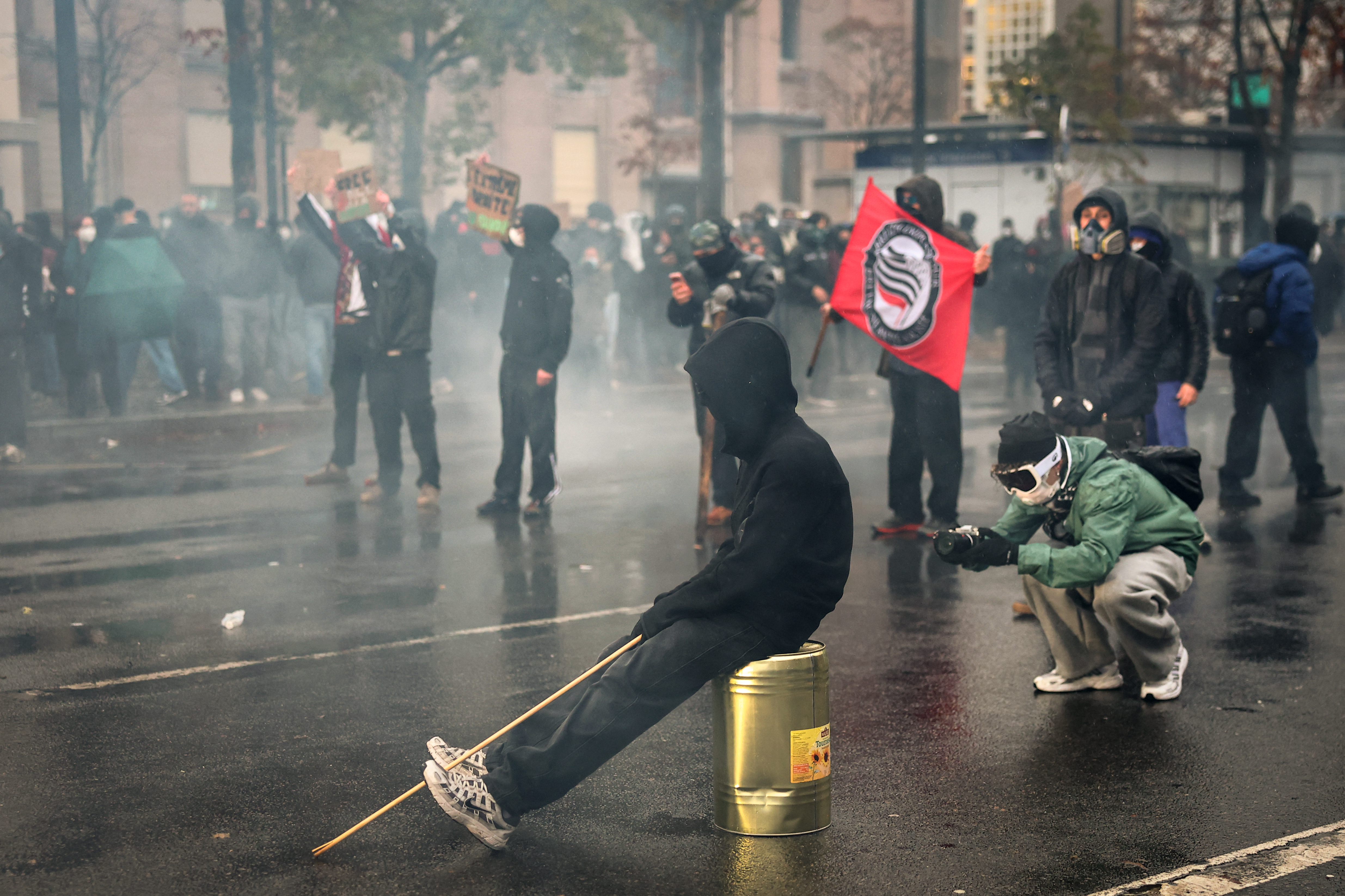 A protester films as clashes erupted at the Porte de Vincennes on the sidelines of a demonstration in favor of purchasing power, the protection of public services, and fiscal and social justice, in Paris on October 24, 2026 as part of a nationwide call for mobilisation bringing together former members of the Yellow Vest movement, labor unions, high school and university students. Protests by high school students over learning conditions sparked a movement that has since spread nationwide, fuelled by broader anger over the rising cost of living. About 70,000 security personnel will be deployed on October 24, 2026, Interior Minister said at a news conference, warning that calls for violence and looting were circulating on social media. (Photo by Sameer AL-DOUMY / AFP via Getty Images)