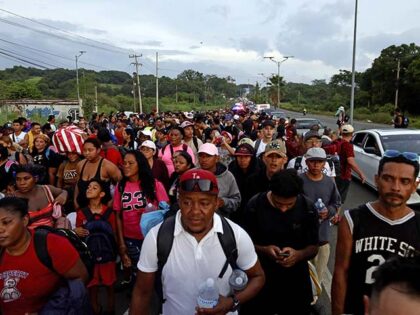 Hundreds of migrants walk through the streets as part of a caravan departing from Tapachul