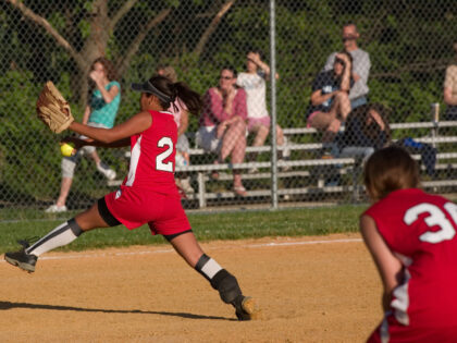 A softball pitcher frozen in mid pitch