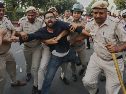 Police detain a protester during a demonstration by the Cockroach Janta Party demanding th