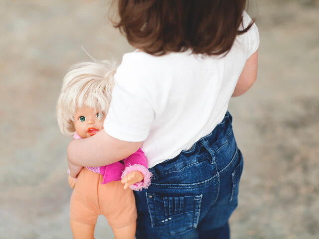 Little girl holding doll