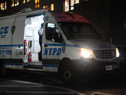 NYPD crime scene investigators walk out of the crime scene unit van to begin the process o