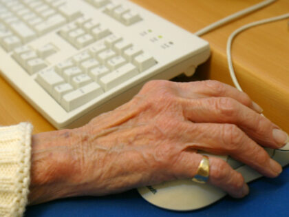 An elderly woman using a computer mouse. (Photo by Andrew Aitchison/In Pictures Ltd./Corbi