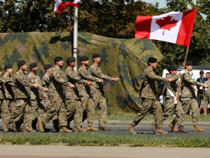 Canadian army soldiers participate in a military parade along a highway in Warsaw, Poland,