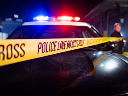Flashing Lights, Hood of Cop Car, and Police Line Do Not Cross - stock photo