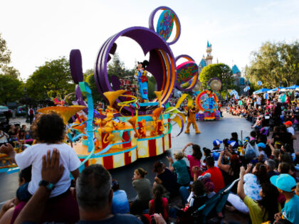 Crowds of guests gather to watch Mickey Mouse in "Mickey's Soundsational Parade&