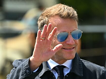 France's President Emmanuel Macron waves as he arrives to visit sports facilities in Loude