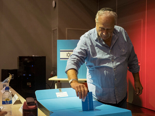 A man places vot envelope into a ballot box at the Nation Community Center in West Jerusal