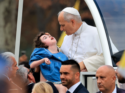 TOPSHOT - Pope Leo XIV blesses Marie-Garance Noel, a child with multiple disabilities, as
