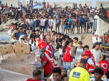 CEUTA, SPAIN - SEPTEMBER 07: The Red Cross is distributing food on El Trampolin beach, on