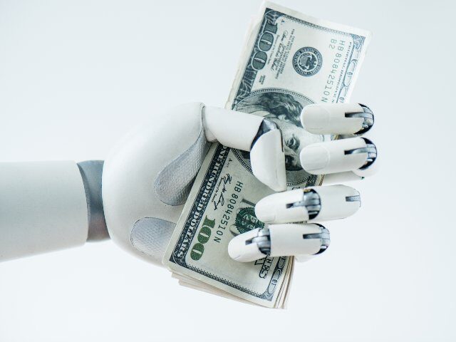 close-up view of robot holding dollar banknotes isolated on white
