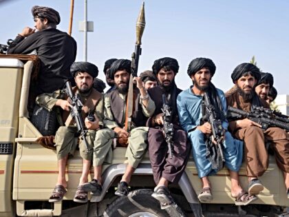 Taliban security personnel of Afghanistan military's 205 Al-Badr Corps sit atop a military
