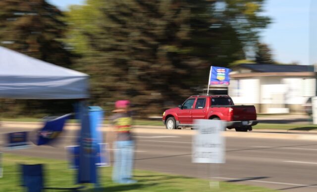 A car flying the Alberta flag circles a separatist event in Medicine Hat, Alberta, on Sept