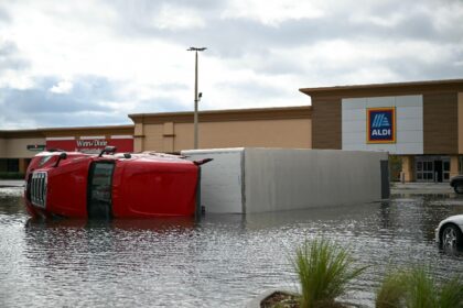 The strong wind overturned a truck in a grocery store parking lot